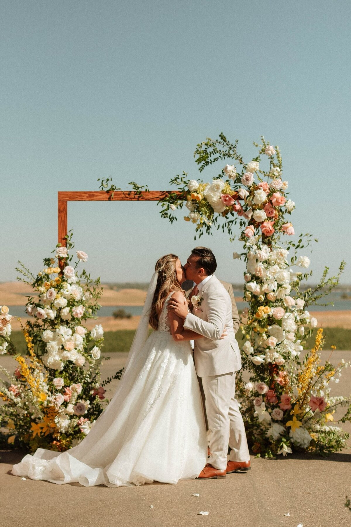 Newlyweds archway kiss | Bella Fleur