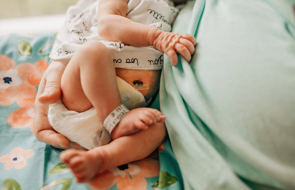 Newborn photography of a baby being held by dad.
