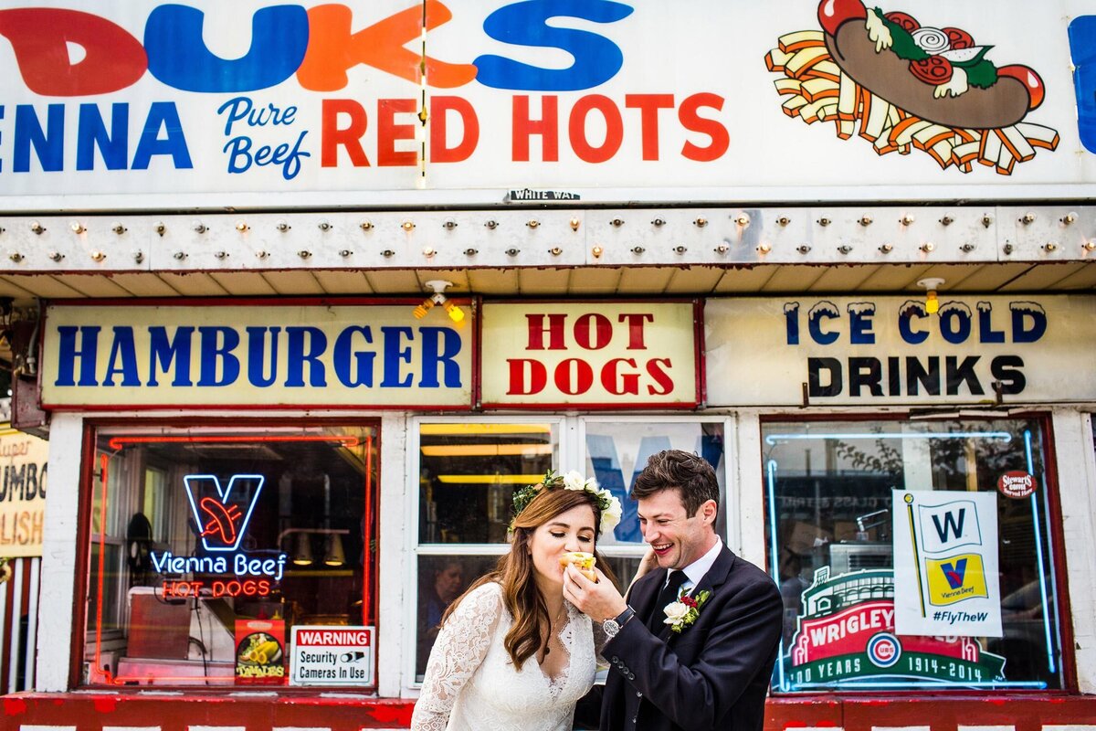A couple eats a hot dog during their Chicago wedding at the Joinery.