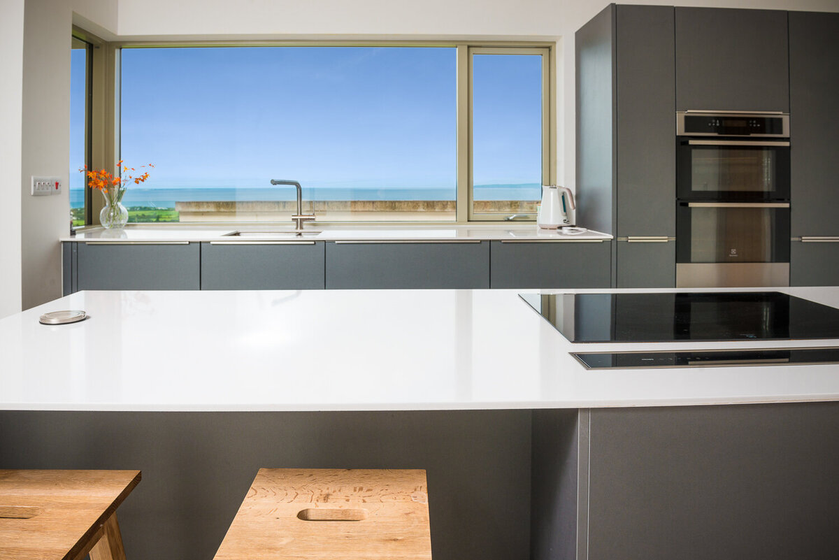 Modern kitchen with grey units and white quartz top