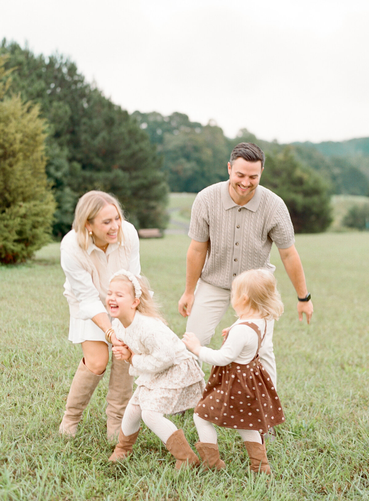 Parents tickle their kids and laugh at Joyner Park. Image by Raleigh maternity photographer A.J. Dunlap Photography.