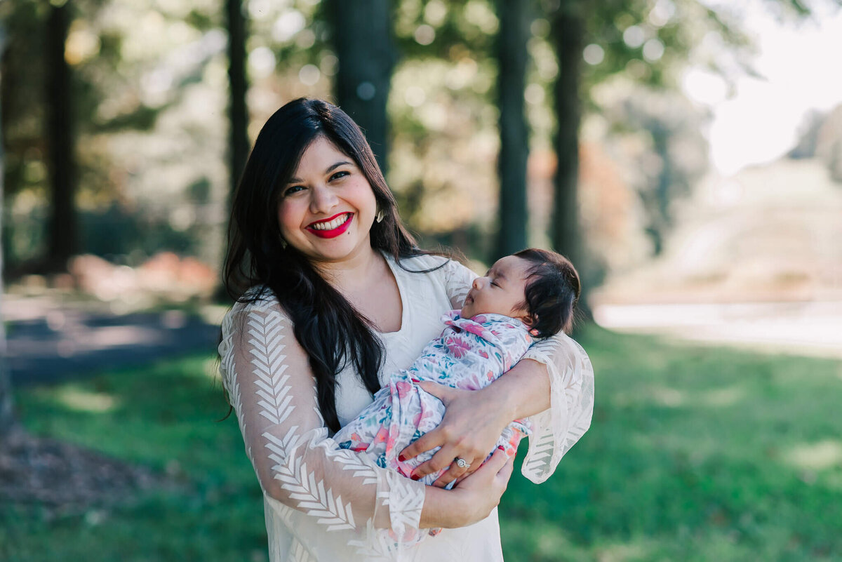 simple portrait of a woman holding her dozing newborn