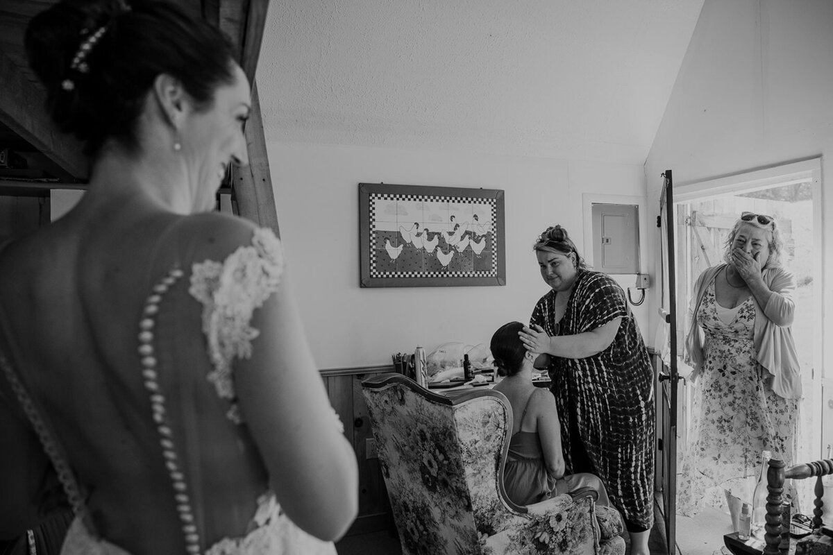 A person smiling as they see someone in a wedding dress for the first time