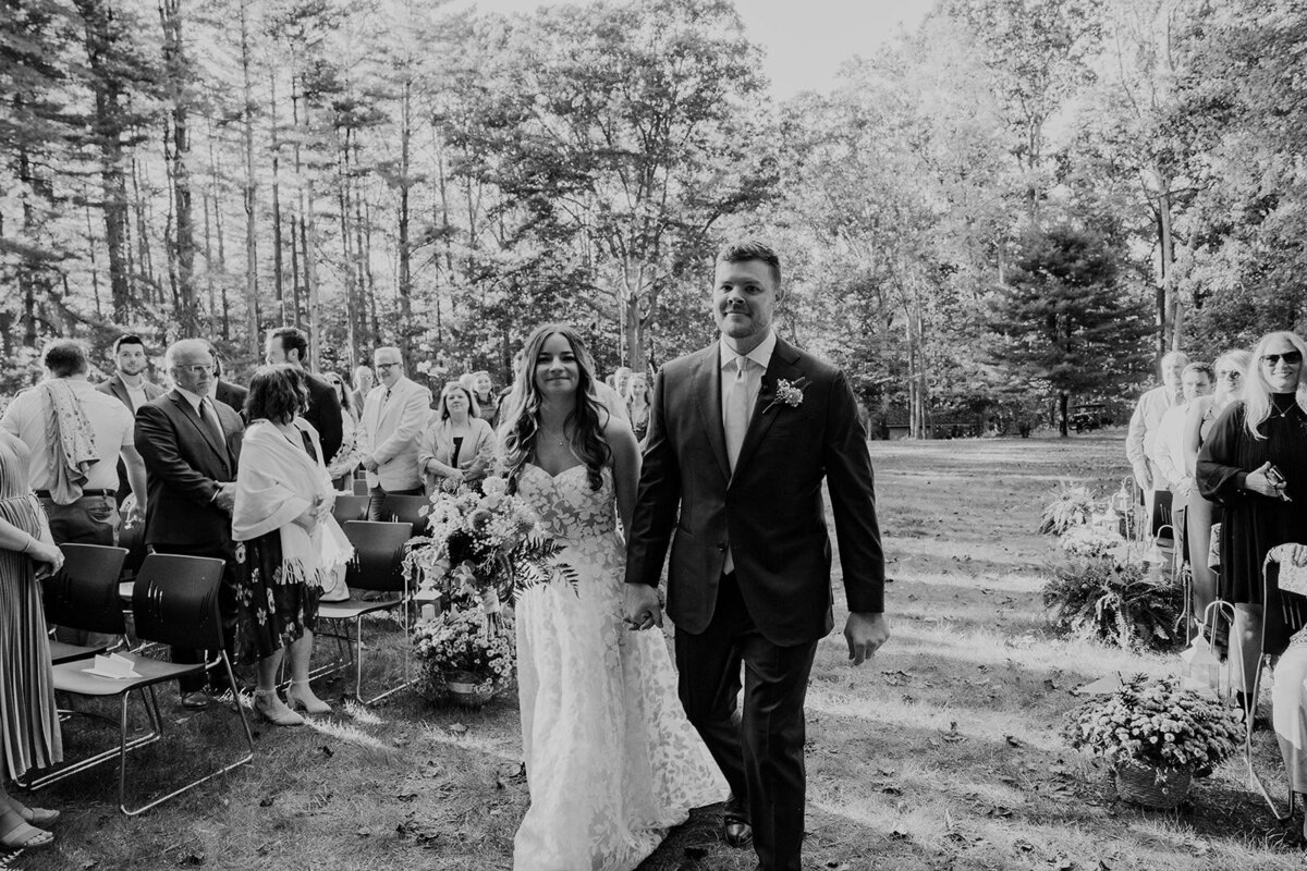 A bride and groom walking down the aisle together on their wedding day.