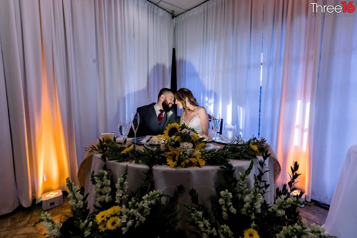 Bride and Groom sitting together at an elaborate sweetheart table