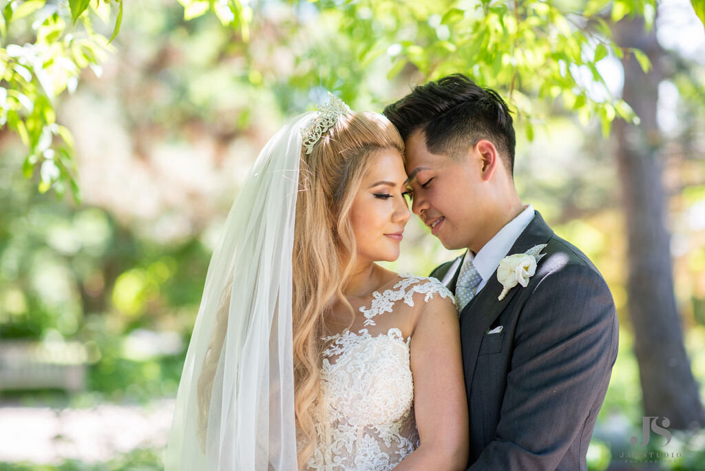 Bride and groom pose for photos after their wedding ceremony in the garden.