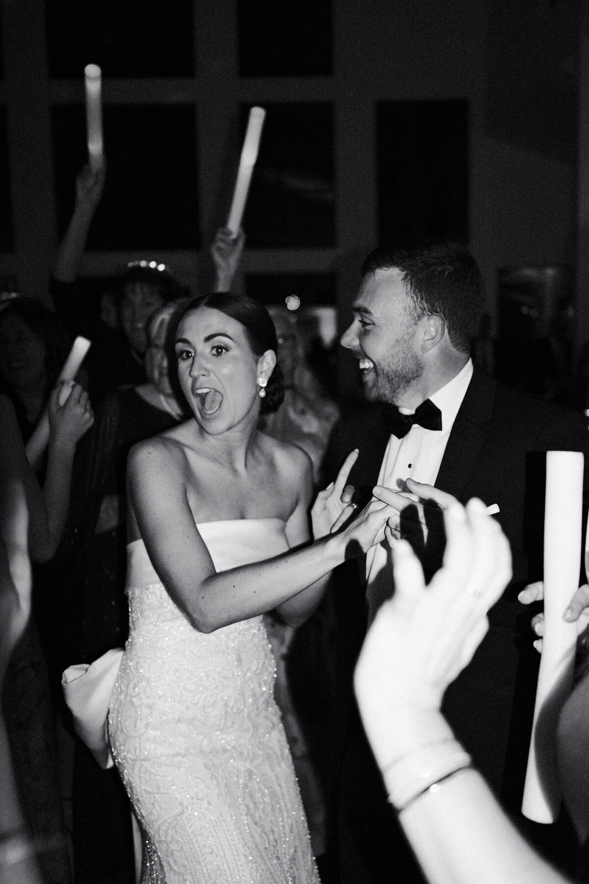 A black and white wedding photo of the bride and groom dancing during their wedding reception