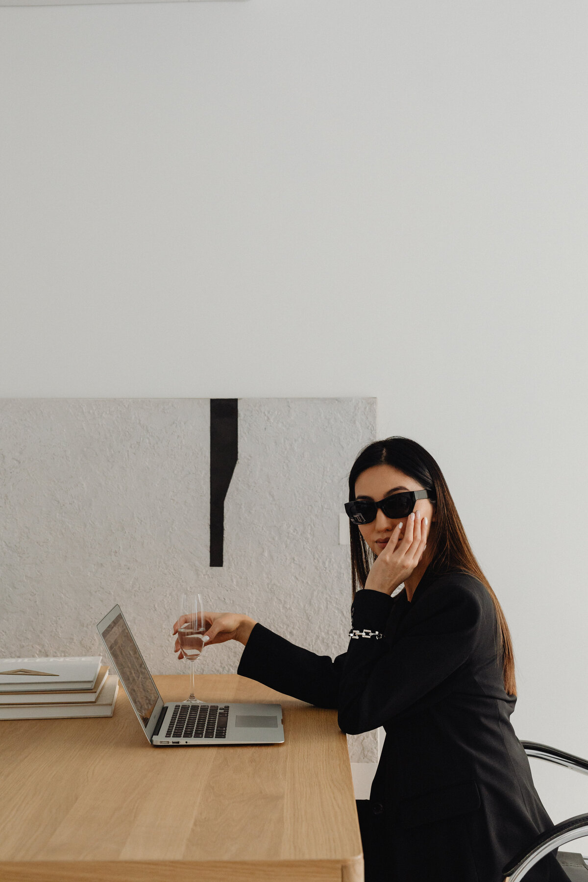 kaboompics_dark-classy-aesthetic-fashion-beautiful-asian-female-entrepreneur-in-black-suit-technology-and-devices-iphone-laptop-airpods-30044