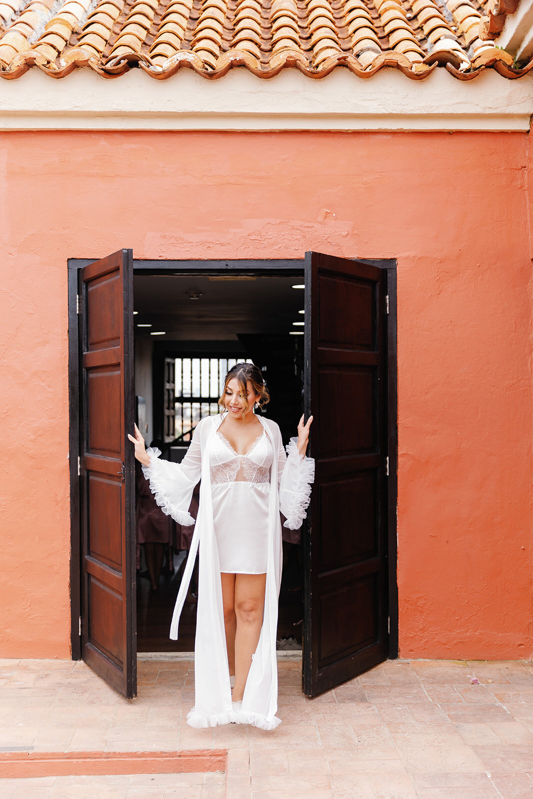 Victoria steps out in a sheer white bridal robe, ready for her Cartagena Colombia wedding, captured by Claudia Amalia Wedding Photography.