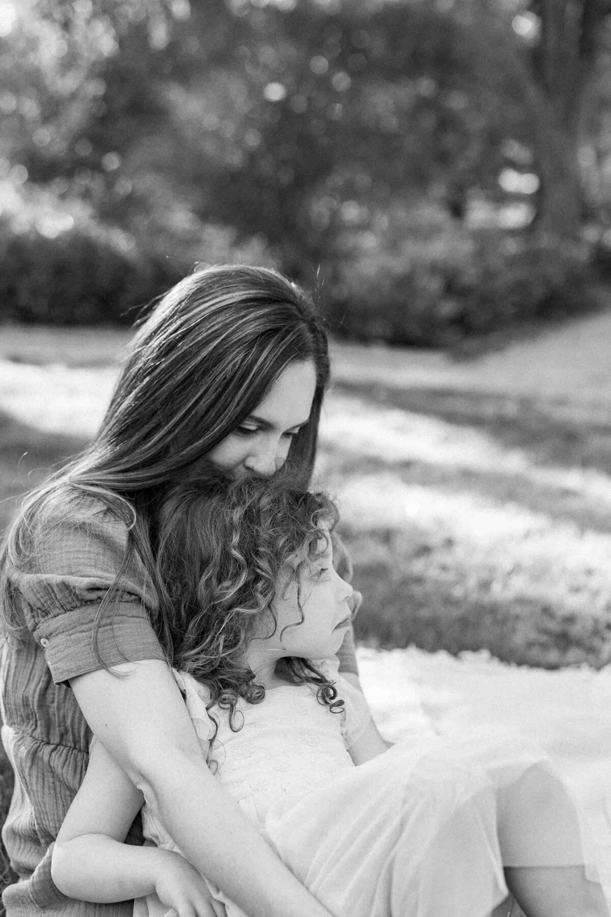 mom kissing daughters hair