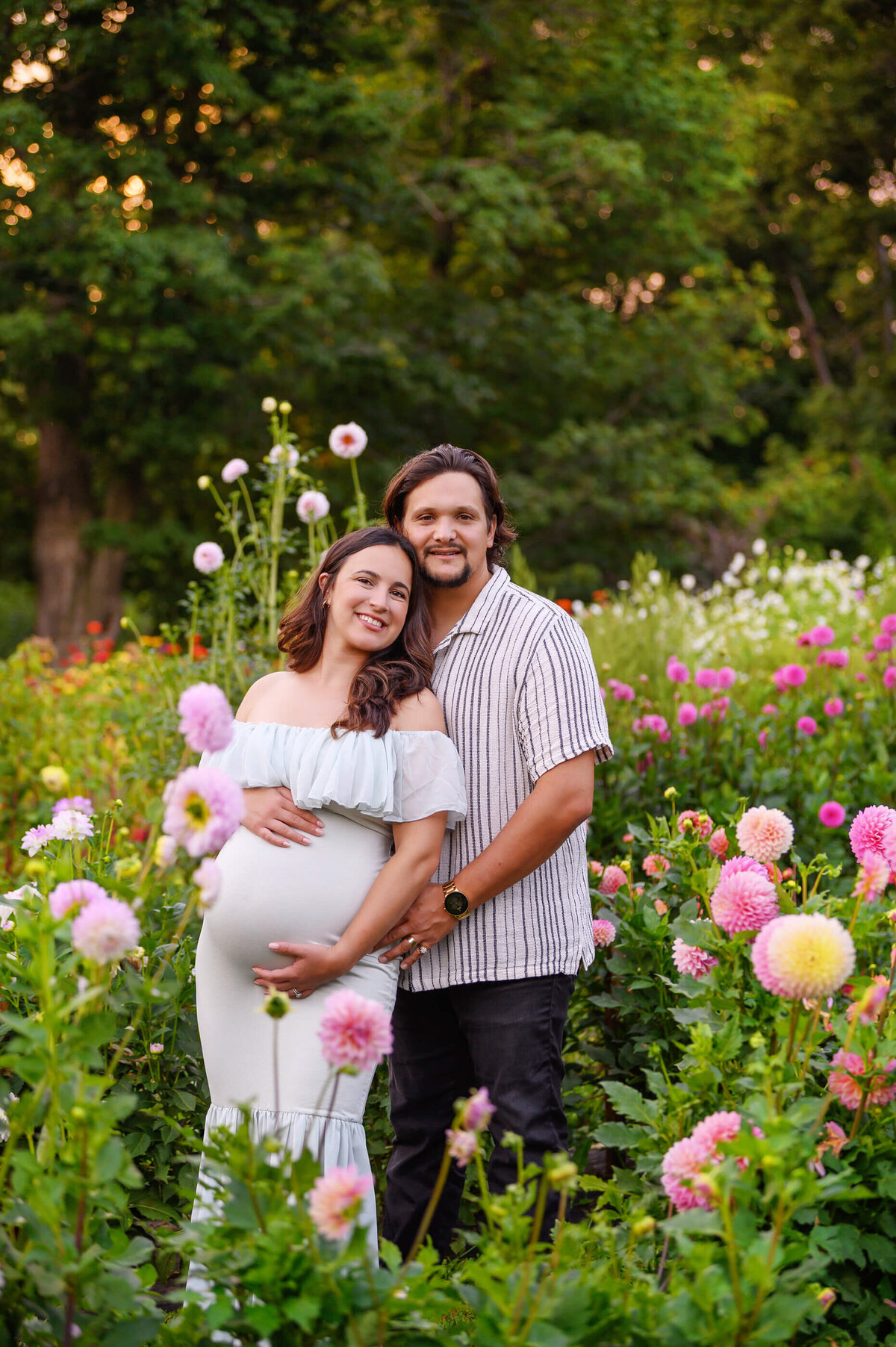 Mom and dad to be at a flower field for their outdoor summer maternity photography session in Burlington, ON