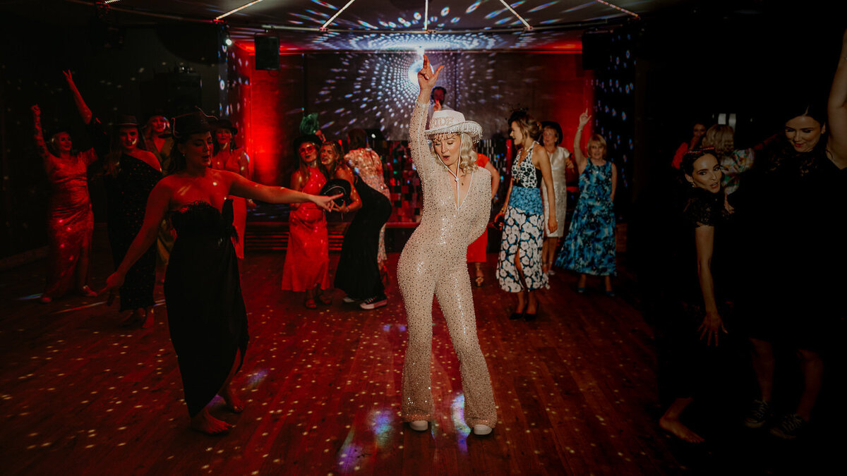 Bride dancing on the dance floor at Elmore Court in a sparkly jumpsuit.