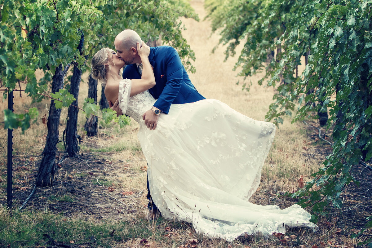 bride and groom dipping in grape vines