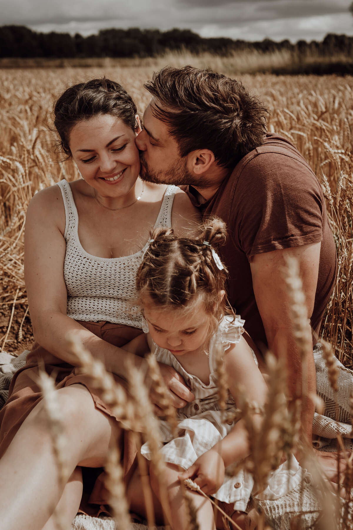 Gezin speelt in graanveld tijdens gezinsshoot