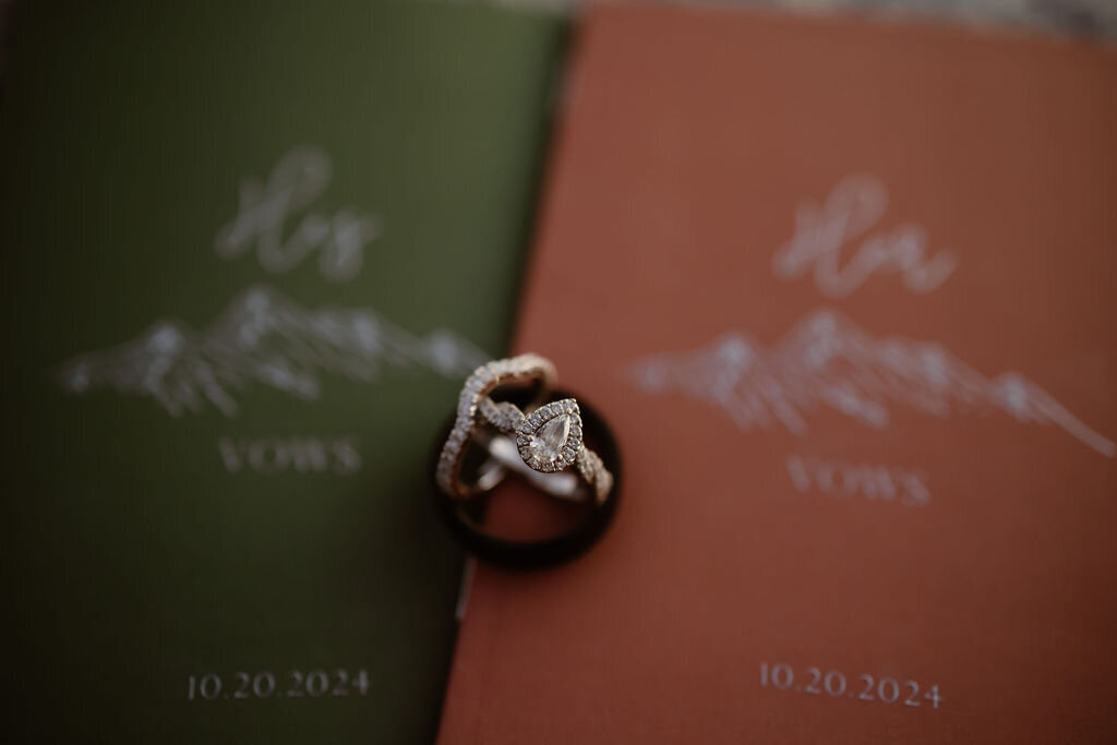 Gatlinburg photographers photographs wedding rings and engagement ring on top of two vow books for gatlinburg elopement 