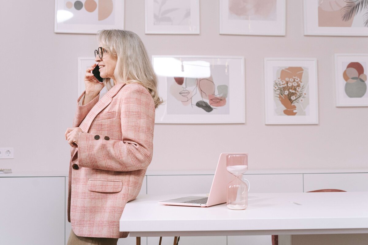 business woman in pink suit talking on phone