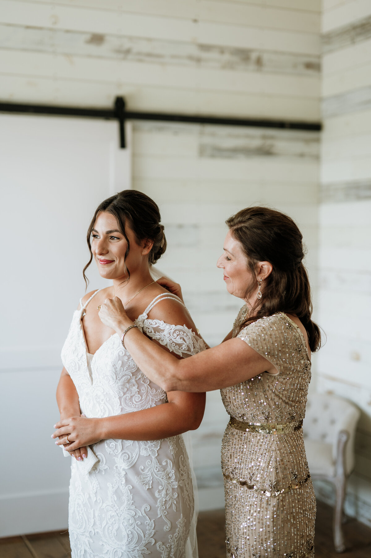 Bride and bridesmaid getting ready in white room