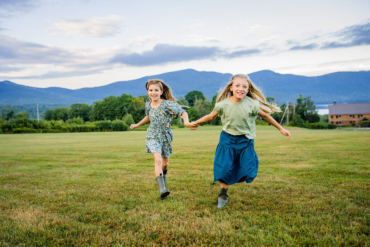 sisters running through field holding hands at mountain top inn chittenden vermont