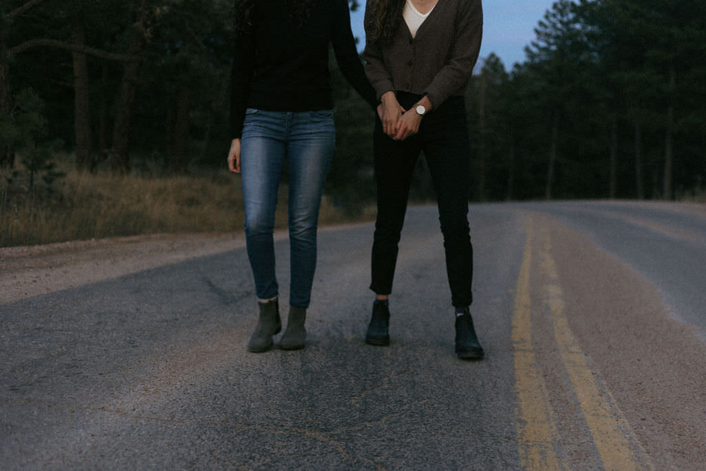 A couple holding hands and standing in a road.