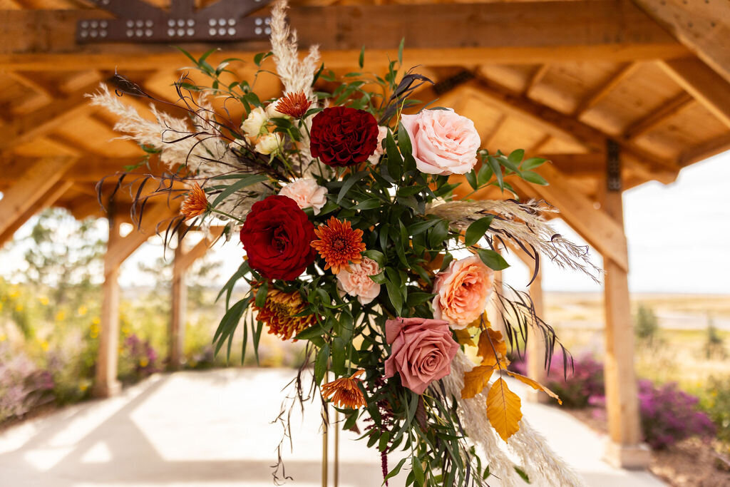 Fall floral arrangement with burgundy, blush, and peach flowers.