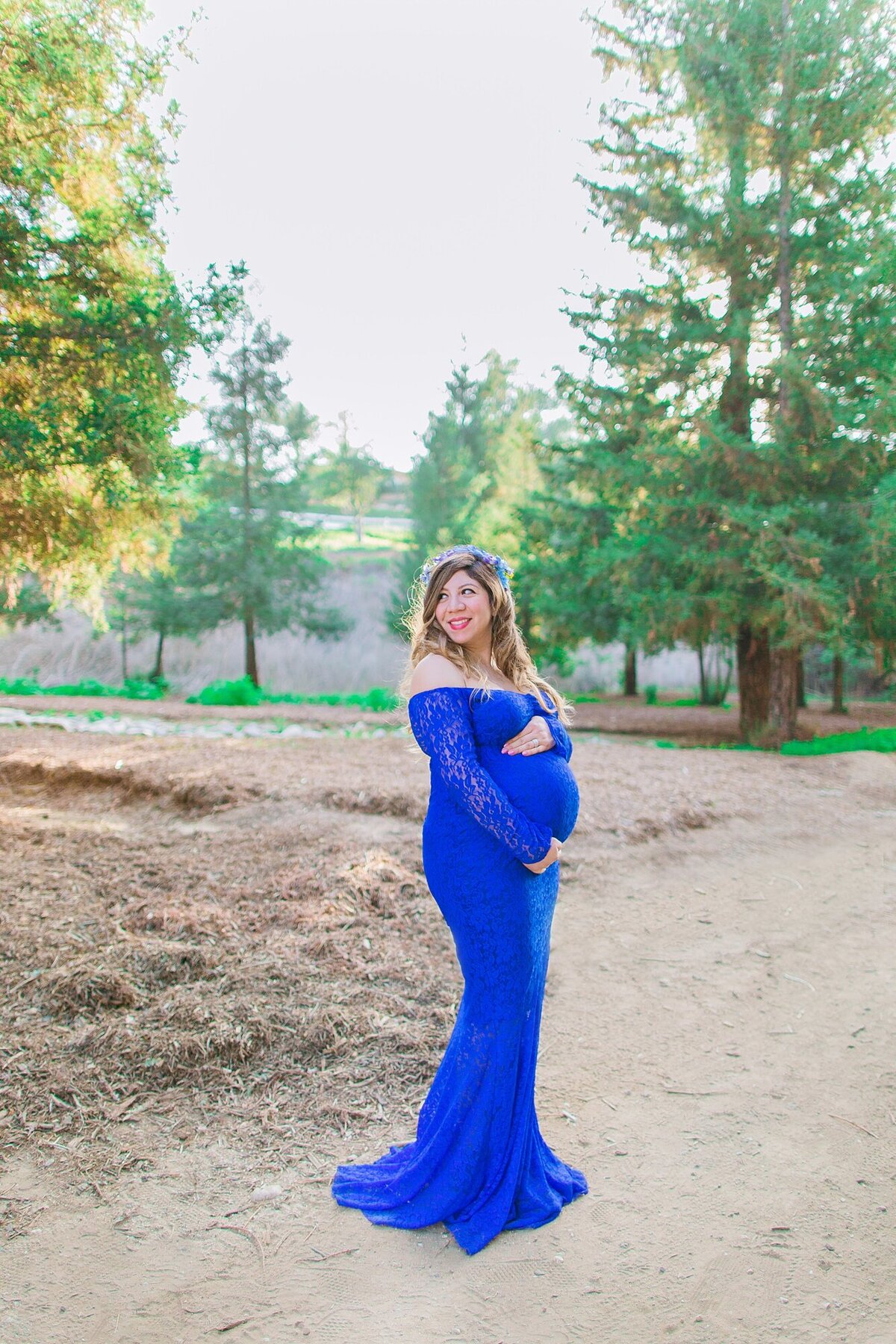 mom holds baby belly in the forest