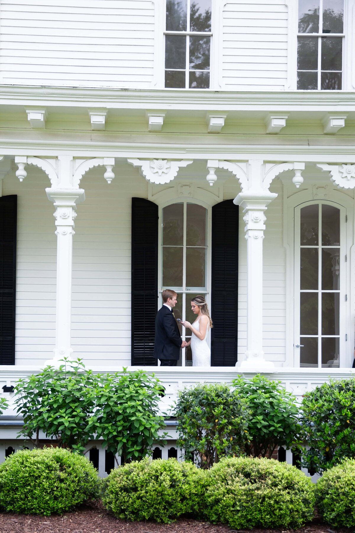 Emotional vow exchange between bride and groom on the porch of the Merrimon-Wynne House in Raleigh.