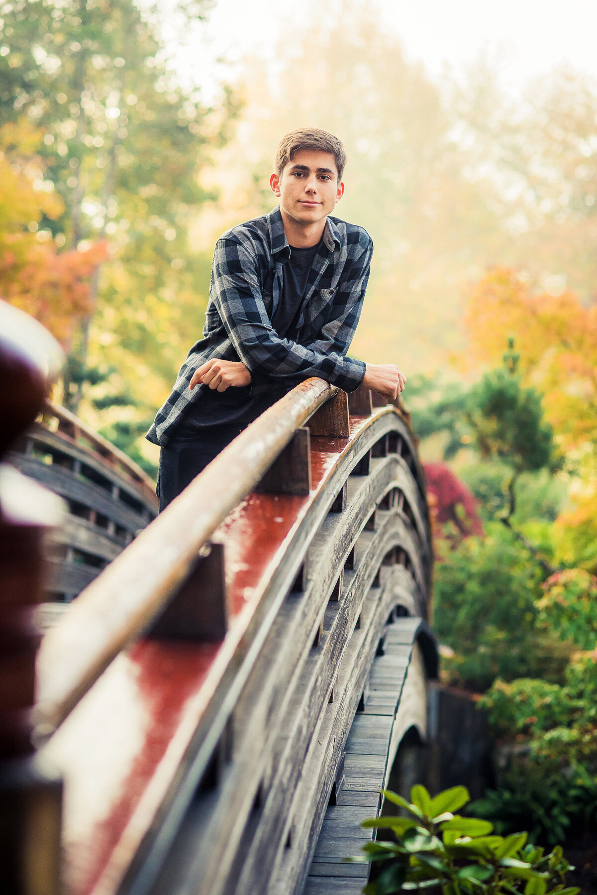 senior boy leaning on bridge