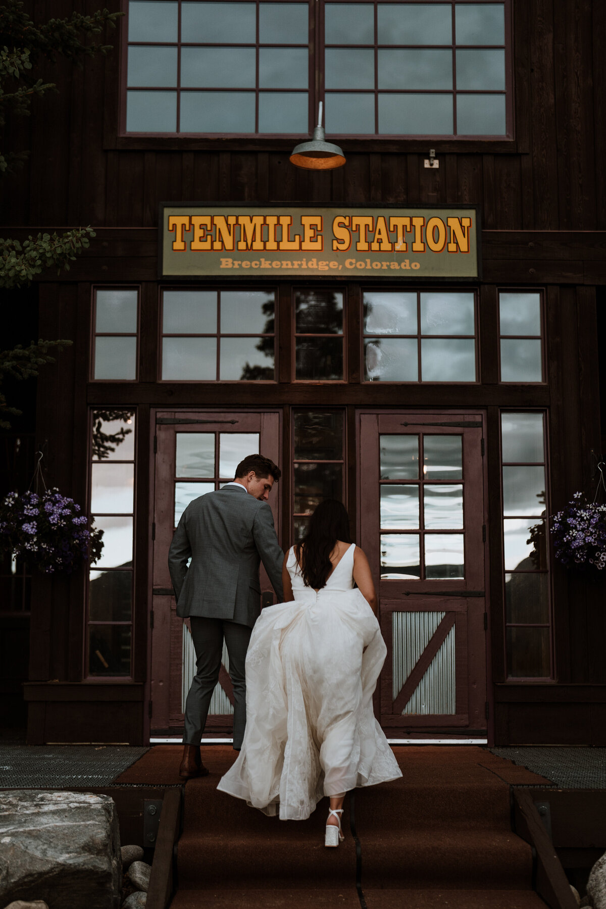 Bride and groom walk into Ten Mile Station in Breckenridge after mountain wedding ceremony.