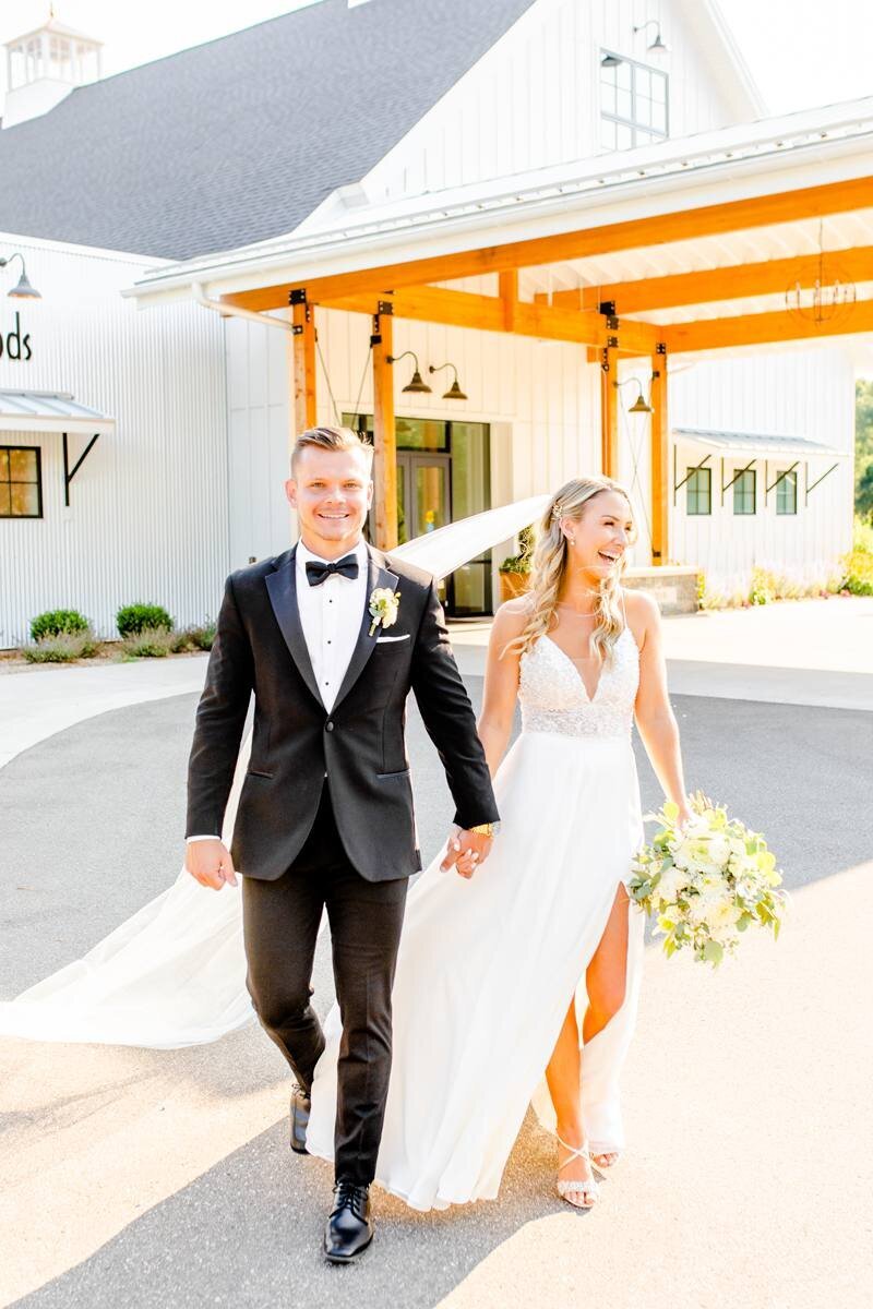 bride and groom laugh while walking together