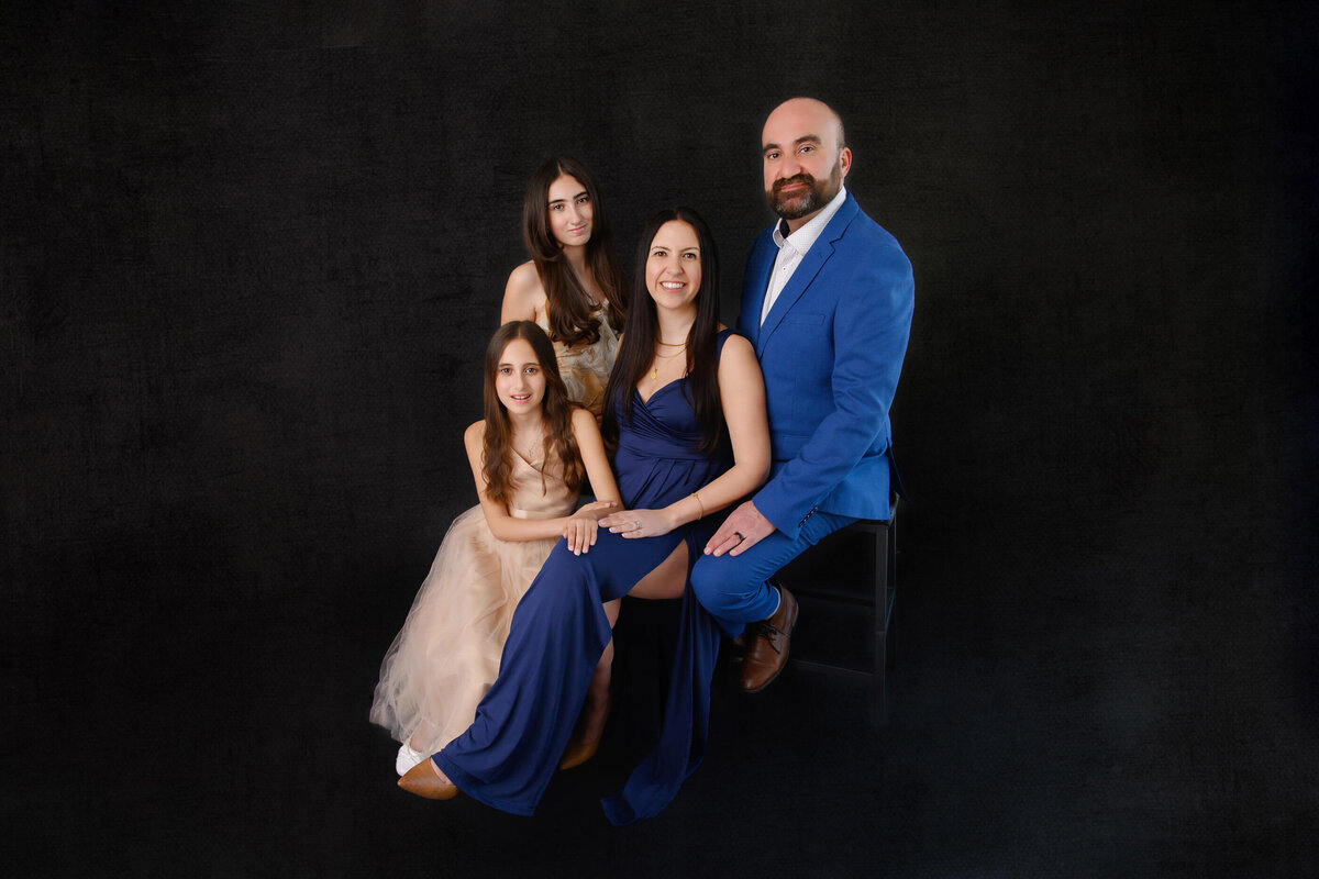 mom and dad with their two daughters at their formal in-studio family portrait session in Burlington, ON