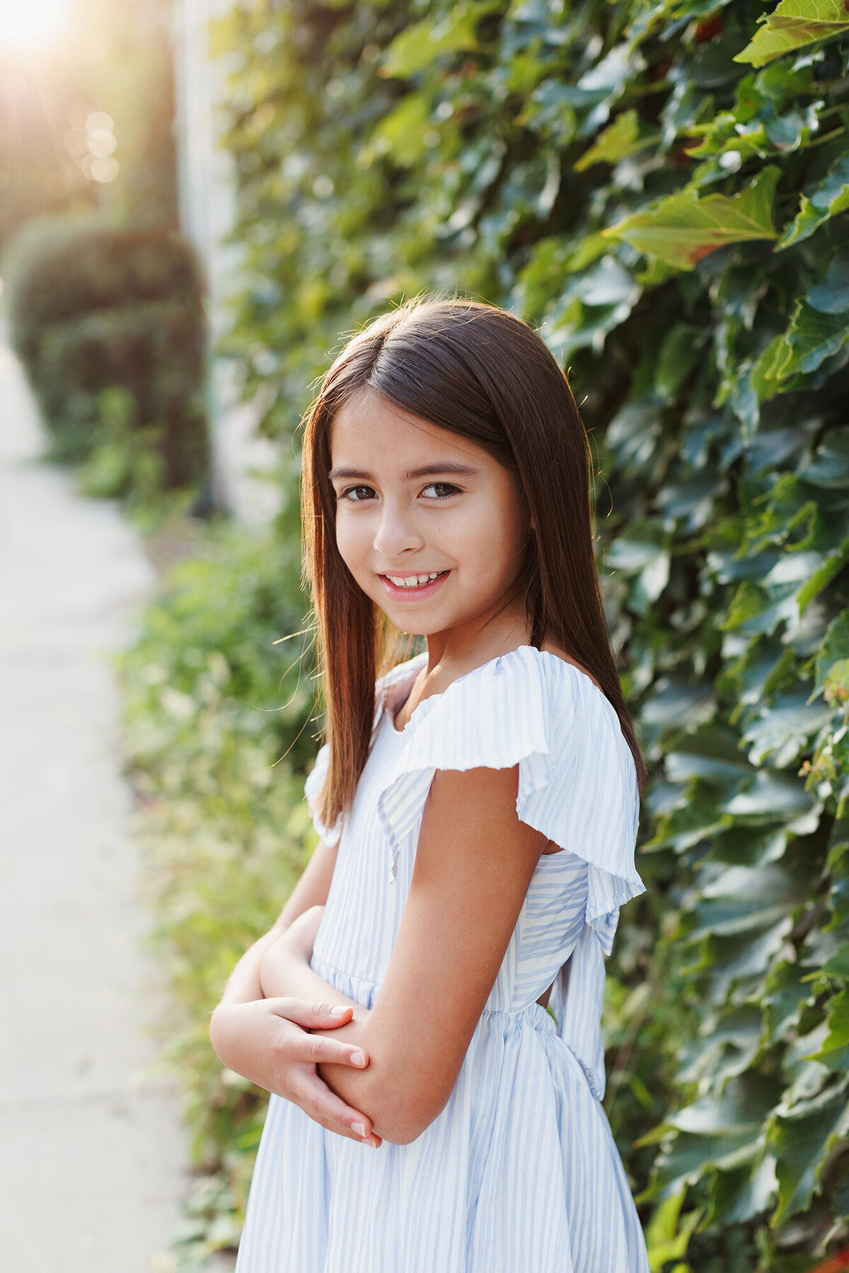 girlposesinfrontofwallwithleaves