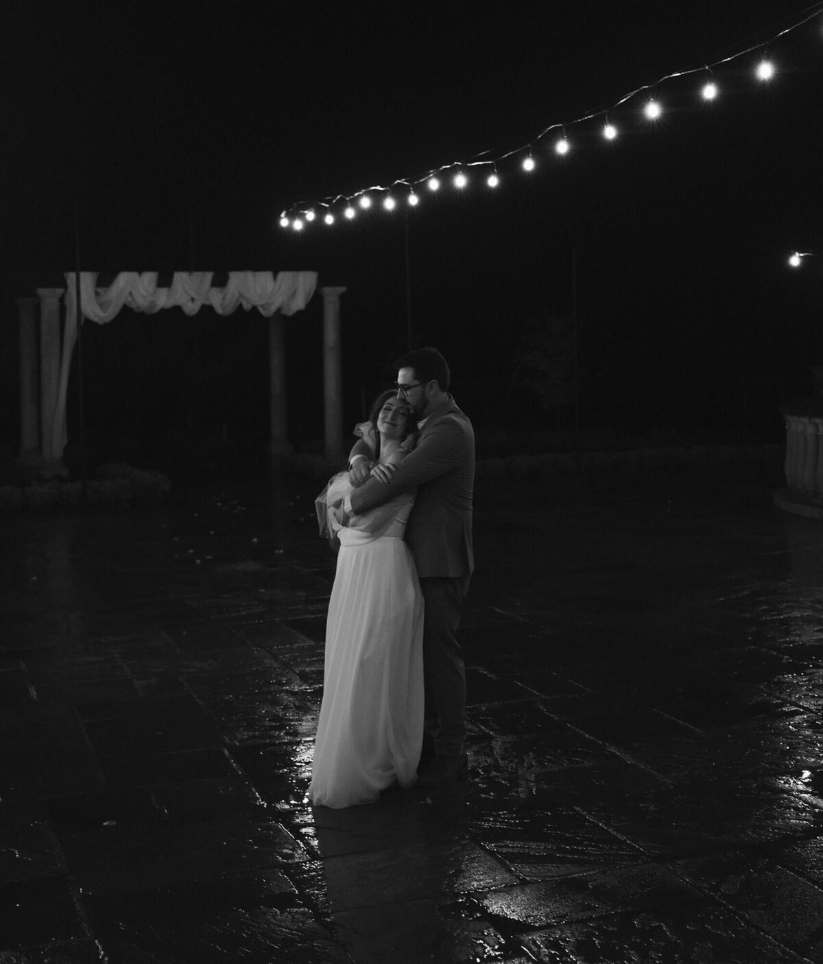 A bride and groom embrace outdoors at night at the Chateau De Lis.