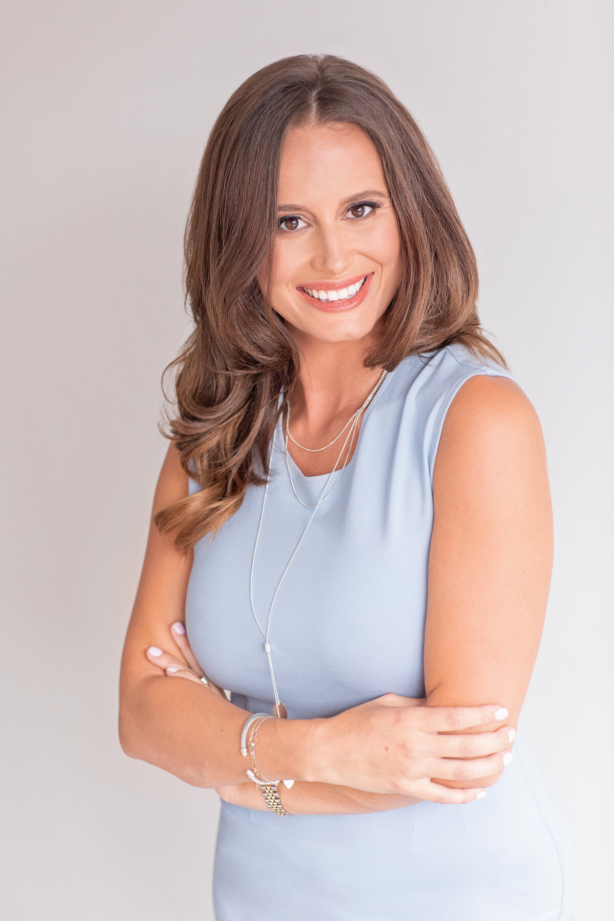 Confident woman with arms crossed in professional portrait