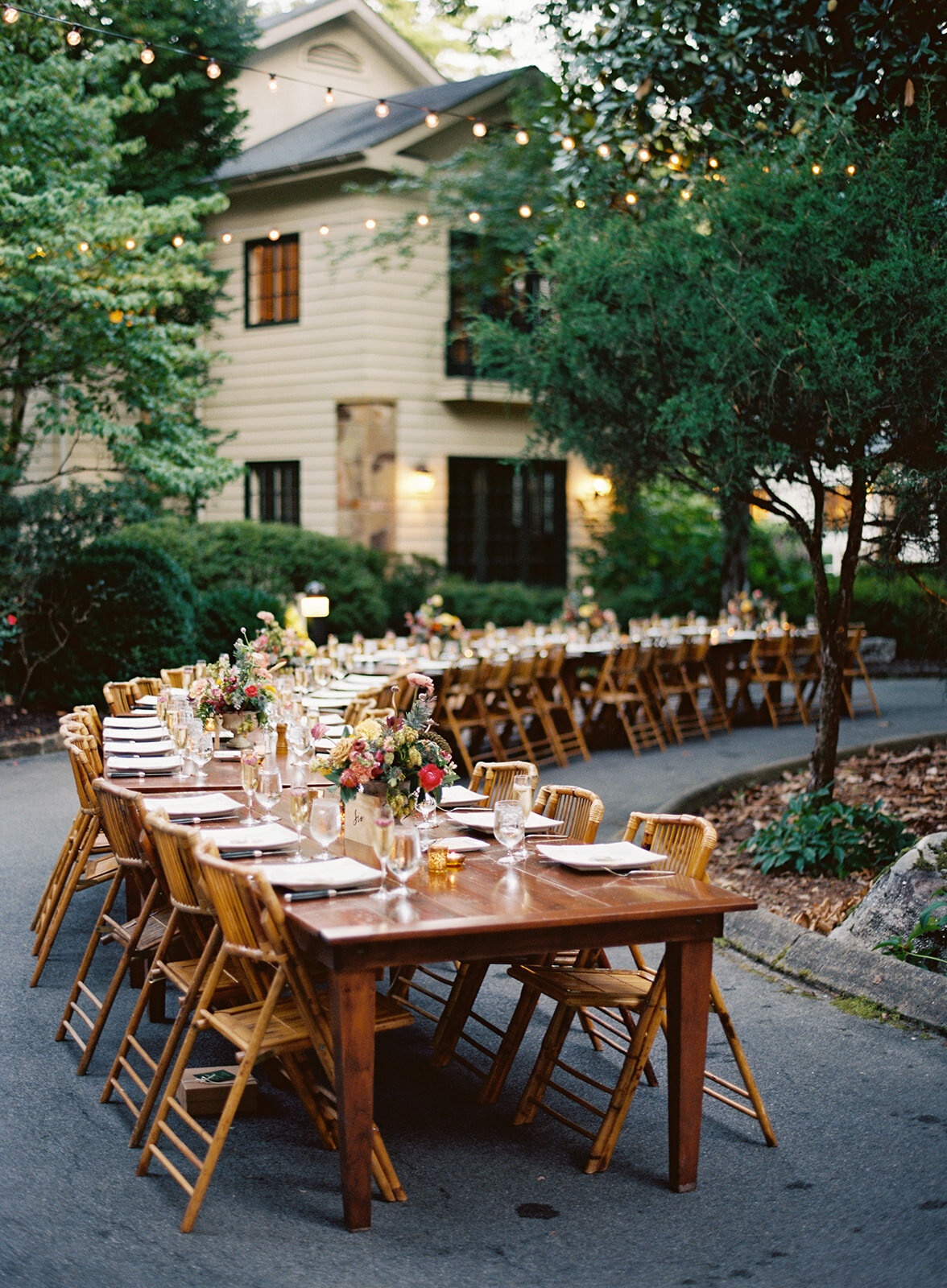 Welcome dinner on the front drive with wildflower centerpieces using ranunculus, chinos, hops, blackberries, persimmons, hops, garden roses, and natural, asymmetrical greenery. RT Lodge and Nashville wedding florist.