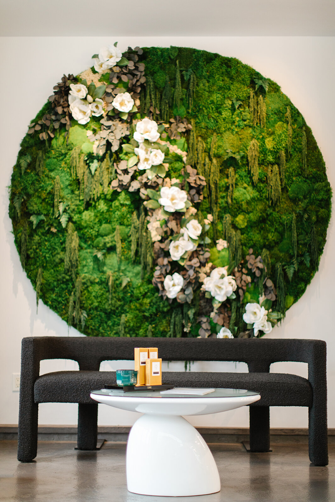 black modern couch with round floral wall behind