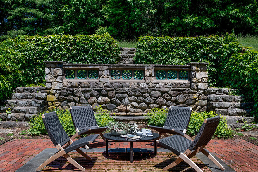 Interior design companies in Boston style a historic garden with modern furniture and a serene water feature, blending contemporary elements with classic charm.