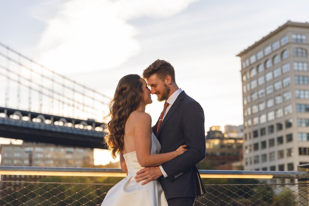 Bride and groom sharing sunset moment by Manhattan Bridge
