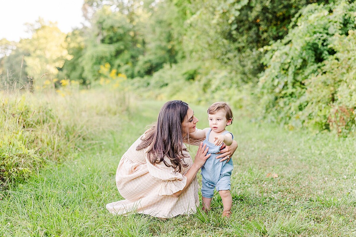 mother bend down to son during Family photo session with Sara Sniderman Photography at Heard Farm in Wayland Massachusetts