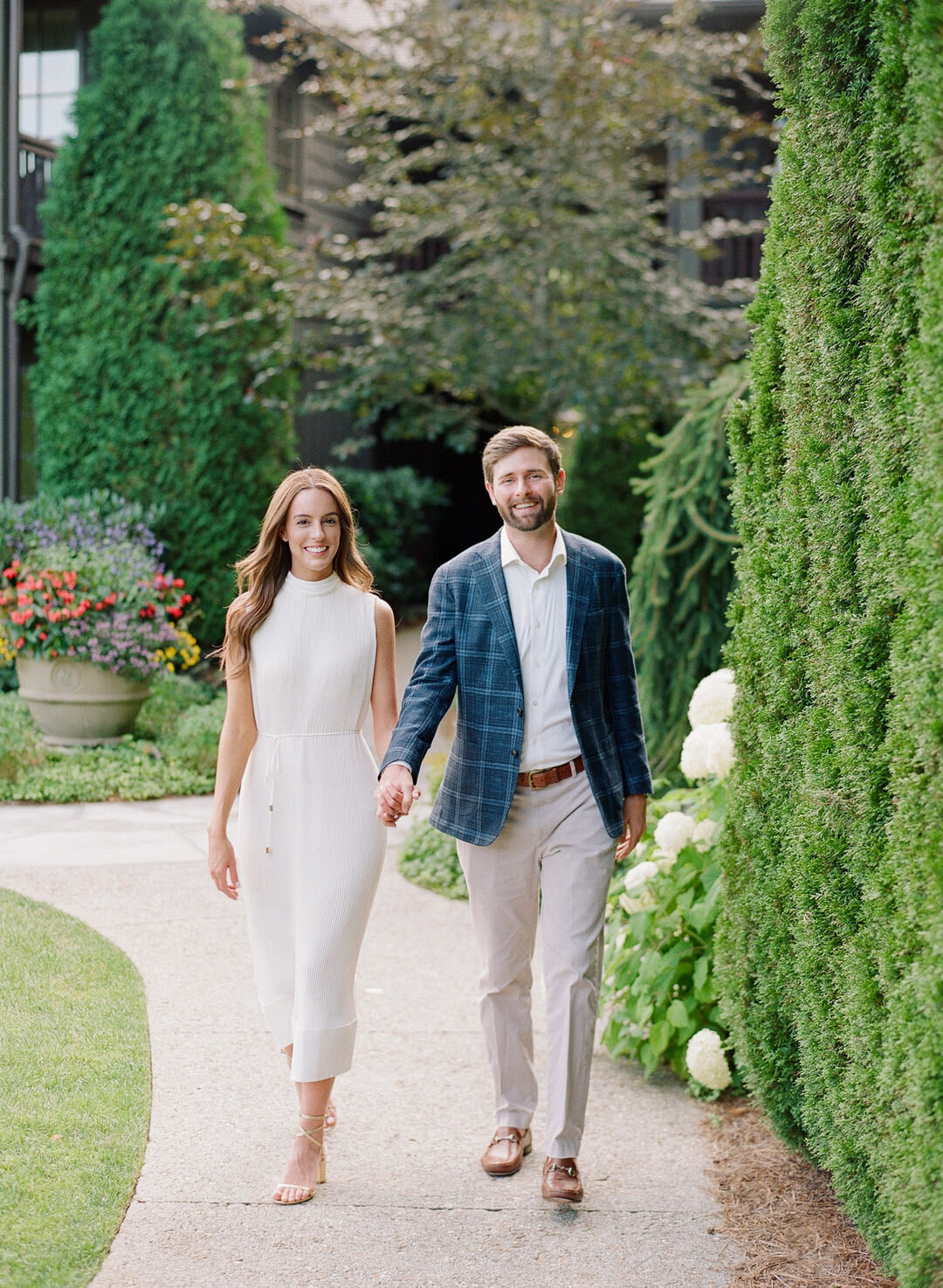 couple walking toward camera smiling and holding hands