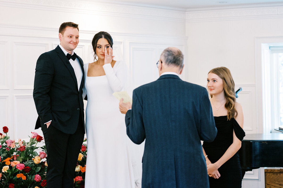 Bride tearinf up at the ceremony listening to her grandpas speech. Minnesota wedding photographer capturing it.