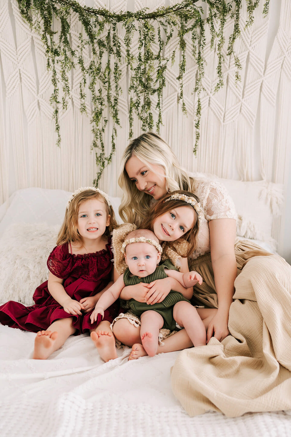mom cuddling daughters in bed during Branson MO family photography session