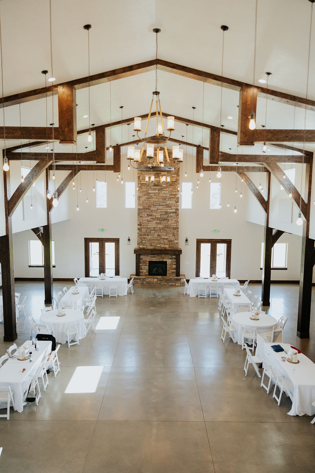 The grand hall set for a reception, with the stone fireplace at the far end
