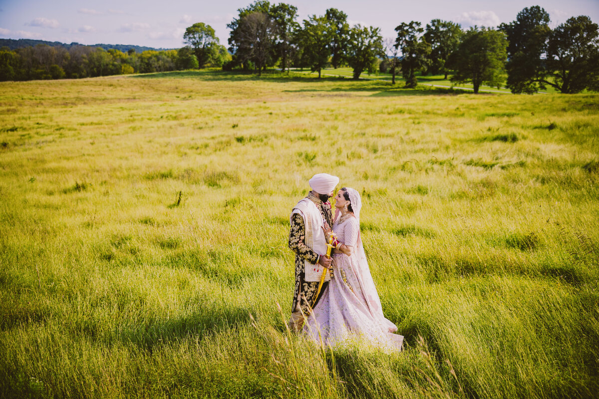 A sikh wedding couple share a moment in an open field at the valley forge historical park in pennsylvania