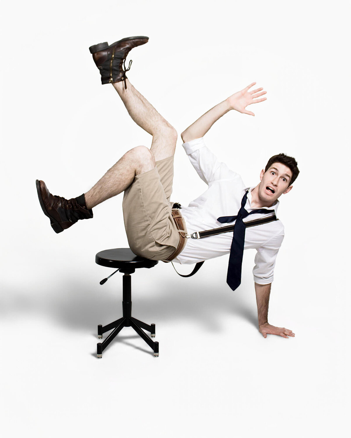 Comical dance portrait of a man falling off a stool on a white backdrop