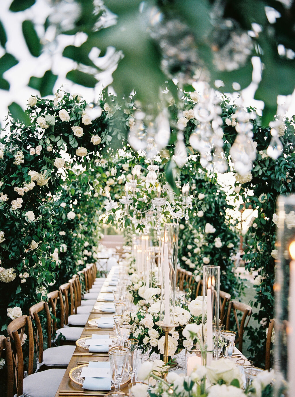 A breathtaking wedding reception setup featuring crystal chandeliers, elegant tablescapes, and lush greenery for a timeless celebration.