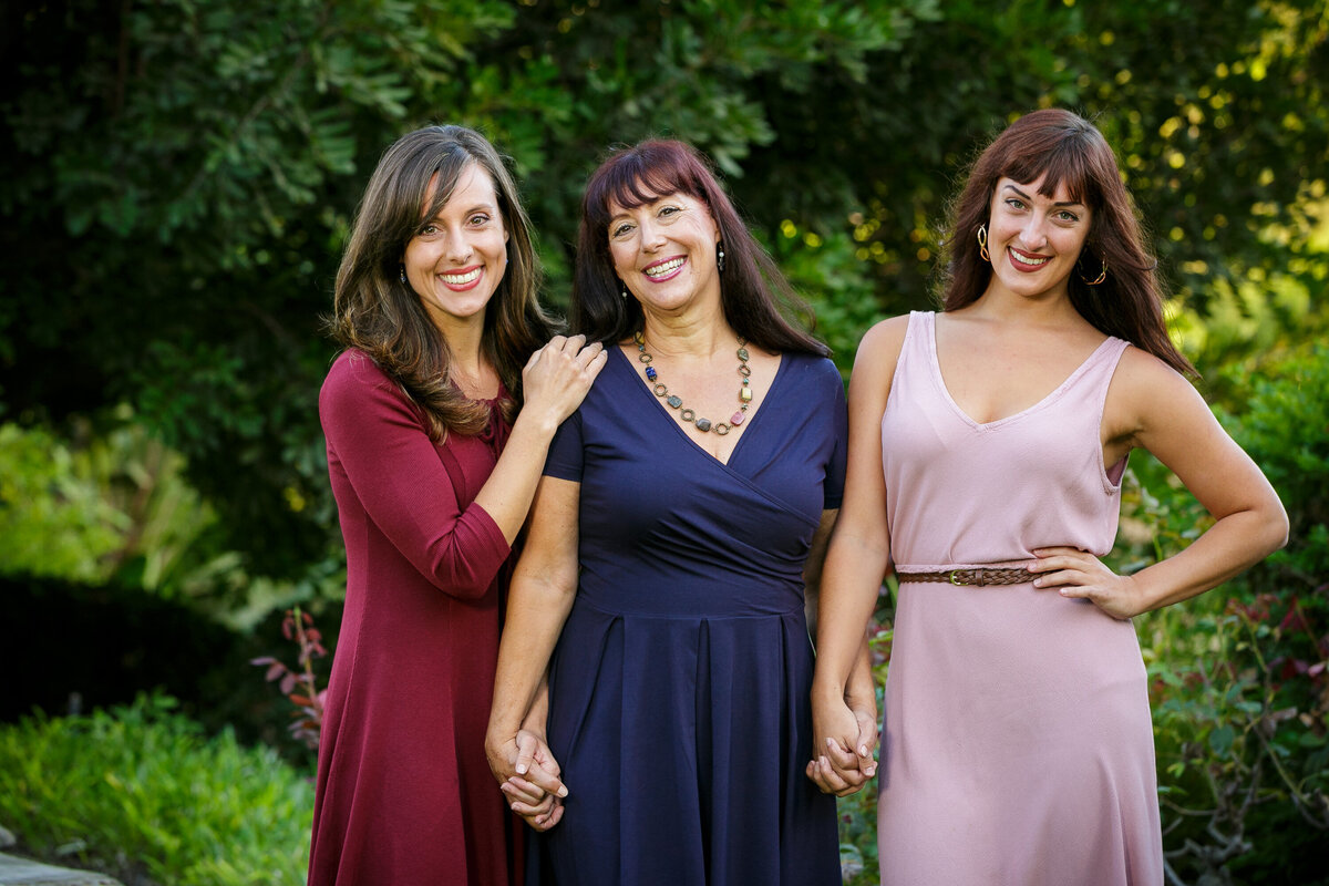 Three women holding hands and smiling