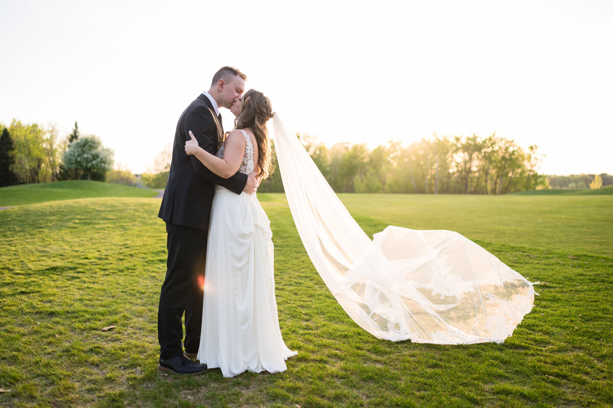 Bride and groom kissing in aisle at their spring Minnesota wedding