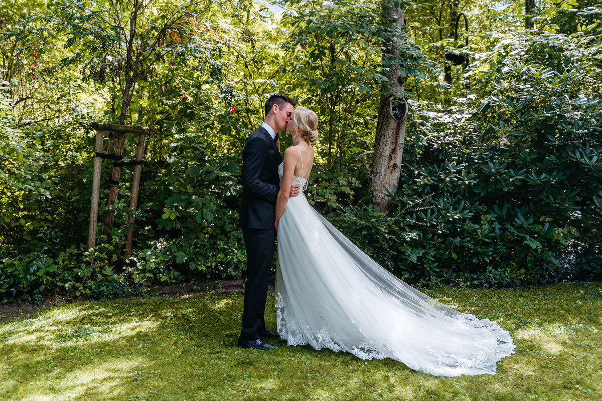 Groom reading vows in shaded garden area