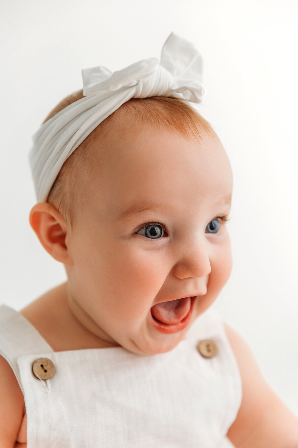 baby girl smiling in white outfit in Phoenix Milestone Portrait session