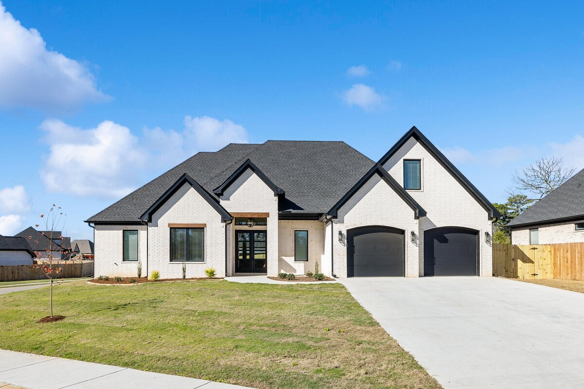 Front of 6011 Majestic Waters. White house with black trim and wood details.